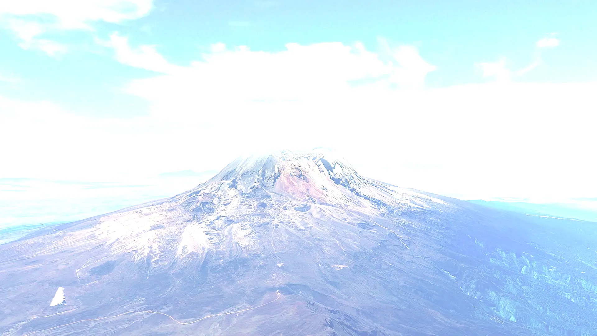 Kilimanjaro's snow-streaked summit seen from the air, with the plains stretching away behind it