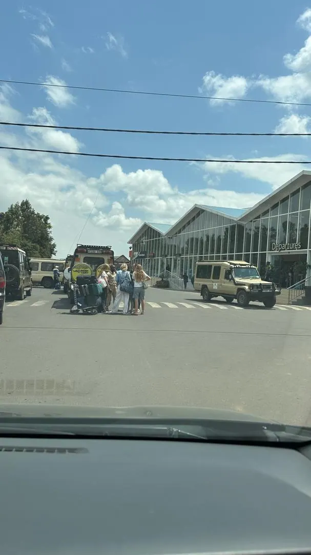 An airport forecourt seen through a vehicle windscreen