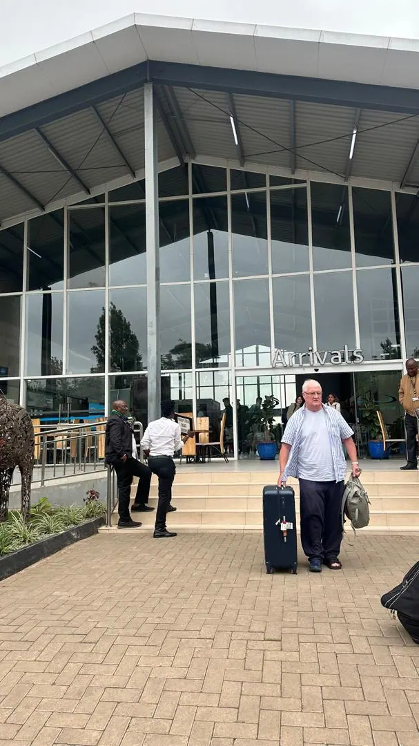 A traveller with luggage outside an airport terminal